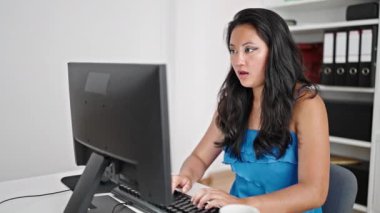 Genç Çinli iş kadını ofiste kutlama için bilgisayar kullanıyor.