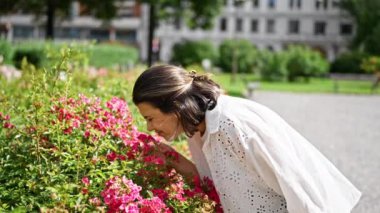Güzel, genç İspanyol kadın mezarlıkta çiçek kokusu alıyor.