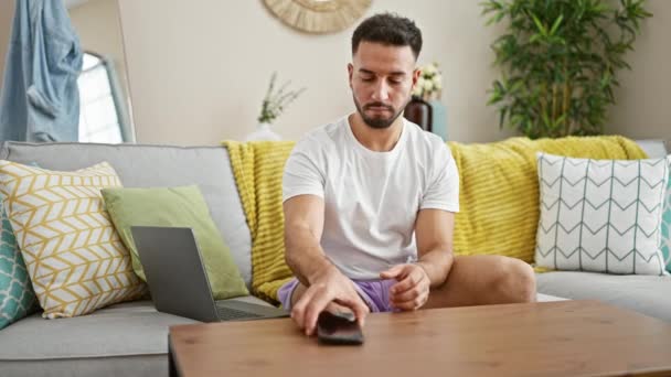 Jovem Árabe Homem Falando Smartphone Usando Laptop Casa — Vídeo de Stock