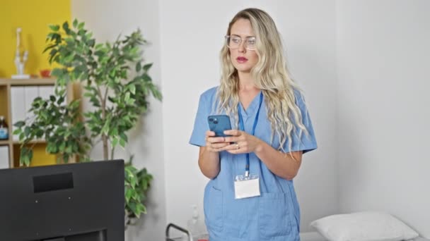 Ung Blond Kvinna Läkare Med Hjälp Smartphone Sitter Massage Bord — Stockvideo