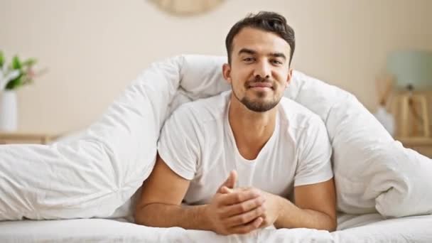 Ung Latinamerikansk Man Ler Säker Liggande Sängen Sovrummet — Stockvideo