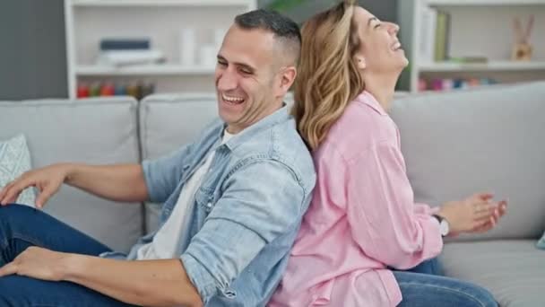 Άνδρες Και Γυναίκες Κάθονται Στον Καναπέ Γελώντας Πολύ Στο Σπίτι — Αρχείο Βίντεο