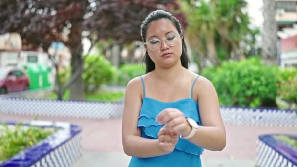 中国的年轻女子在公园里戴着一只严肃的手表 — 图库视频影像