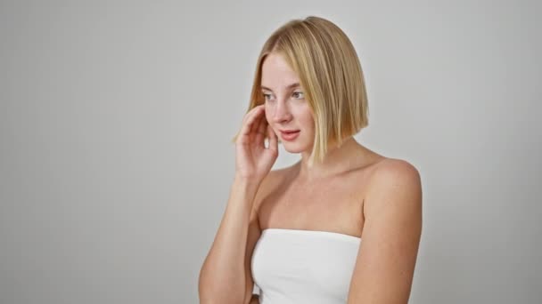 Ung Blond Kvinna Ler Säker Berörande Ansikte Över Isolerad Vit — Stockvideo