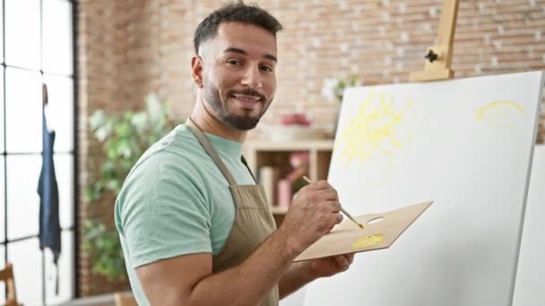 年轻的阿拉伯男子艺术家在艺术工作室里自信地微笑着画画 — 图库视频影像