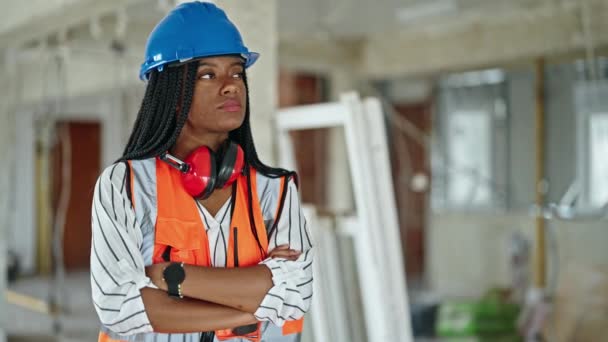 アフリカ系アメリカ人女性の建設現場で腕を組んで立ってジェスチャーや真剣な表情を交差 — ストック動画