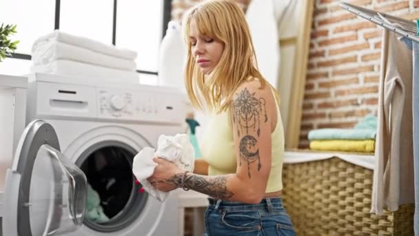 若いですブロンド女性洗濯室で服 — ストック動画