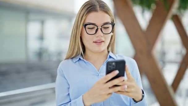 Jovem Loira Mulher Empresária Sorrindo Confiante Usando Smartphone Rua — Vídeo de Stock