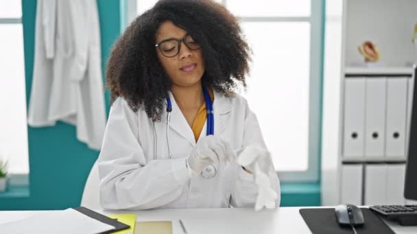 Африканская Американка Доктор Улыбается Уверенно Надевая Перчатки Клинике — стоковое видео