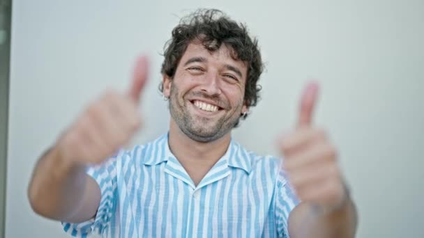 Jovem Hispânico Homem Sorrindo Confiante Fazendo Sinal Com Polegares Para — Vídeo de Stock