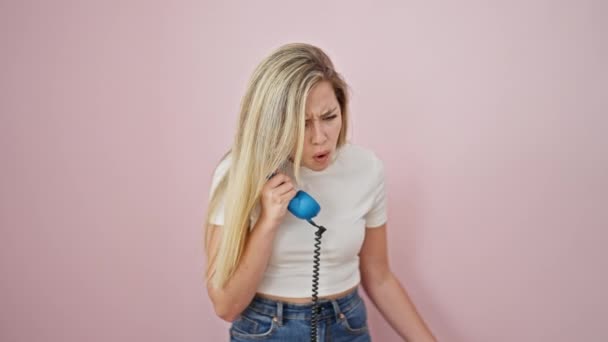Mladá Blondýna Mluví Telefonu Hádky Přes Izolované Růžové Pozadí — Stock video