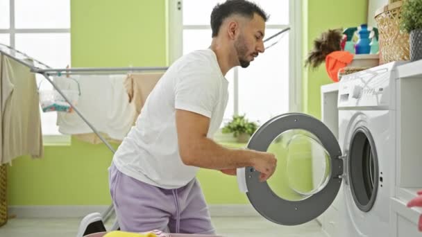 Çamaşır Odasında Çamaşır Yıkayan Genç Arap Adam Yumuşatıcı Havluya Dokunuyor — Stok video