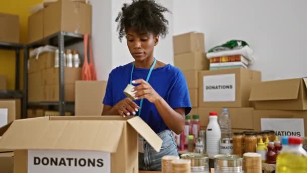 Mujer Afroamericana Voluntaria Empacando Productos Paquete Centro Caridad — Vídeos de Stock