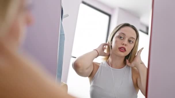 Young Blonde Woman Combing Hair Listening Music Looking Mirror Home — Stock Video