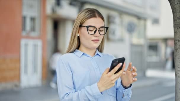 Mujer Joven Rubia Trabajadora Negocios Sonriendo Confiada Hablando Teléfono Inteligente — Vídeo de stock