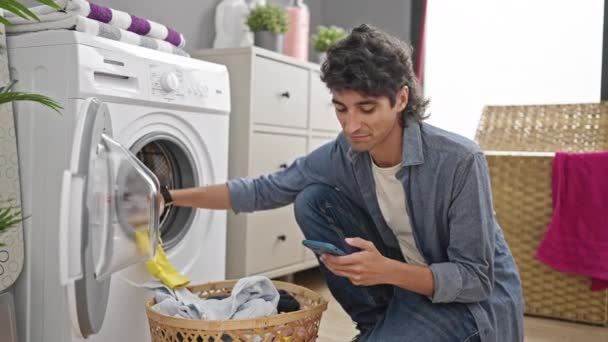 Νεαρός Ισπανός Που Χρησιμοποιεί Smartphone Πλένοντας Ρούχα Στο Πλυσταριό — Αρχείο Βίντεο