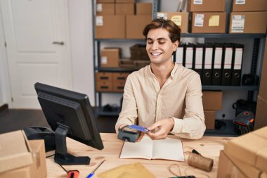 Young caucasian man ecommerce business worker using data phone and credit card at office