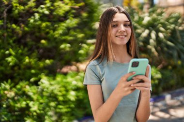 Adorable girl smiling confident using smartphone at park