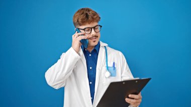 Genç İspanyol doktor, mavi arka plan üzerinden akıllı telefon okuyarak konuşuyor.