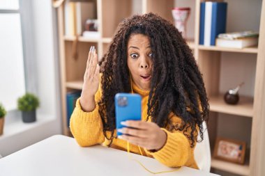 Ayrıca akıllı telefon kullanan iri yarı bir İspanyol kadın korkmuş ve ağzı açık bir şekilde şaşırmış bir şekilde masada oturuyor. 