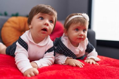 Evdeki kanepede uzanmış iki sevimli bebek.