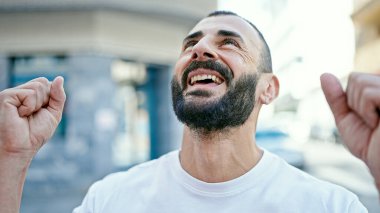 Latin kökenli genç adam gökyüzüne bakıyor.