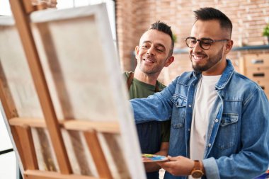 Two men artists smiling confident drawing at art studio