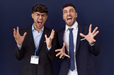 İş kıyafetleri giymiş iki İspanyol iş adamı başarı için deli ve çılgınlığı kutlarken kollarını kaldırmış ve gözlerini kapatmış heyecanlı çığlıklar atıyorlar. Kazanan konsept 