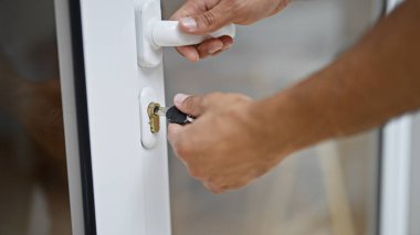 Genç İspanyol adam caddede kapıyı açıyor.