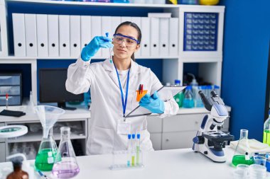 Laboratuvarda test tüpü tutan genç İspanyol bilim kadını.