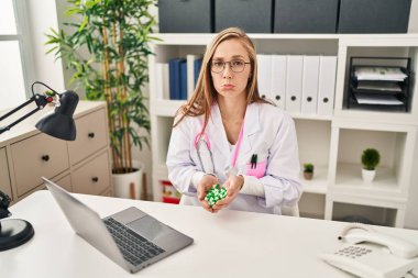 Genç sarışın kadın elinde haplar tutuyordu. Depresyondaydı ve üzüntüden ağlıyordu. Kızgın ve korkmuştu. hüzünlü ifade. 