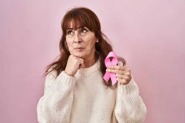 Middle Age Hispanic Woman Holding Pink Cancer Ribbon Serious Face — ストック写真
