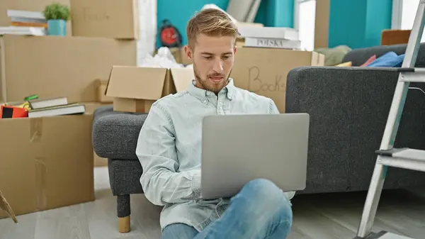 年轻的高加索人坐在新家的地板上 用笔记本电脑 — 图库照片