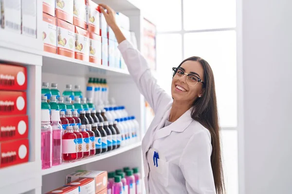 Joven Hermosa Mujer Hispana Farmacéutica Sonriendo Confiada Sosteniendo Botella Medicación —  Fotos de Stock
