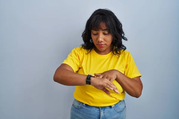 ヒスパニック系の女性立ち上の青の背景チェックザ時間上の手首腕時計 リラックスして自信 — ストック写真
