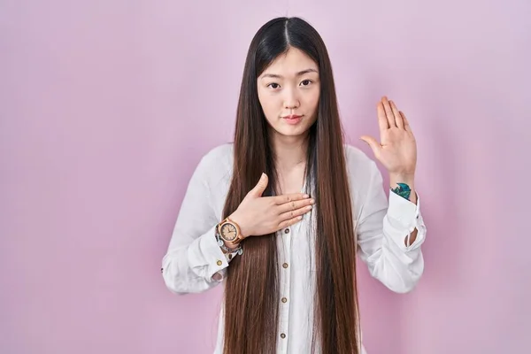 Chinês Jovem Mulher Sobre Fundo Rosa Jurando Com Mão Peito — Fotografia de Stock