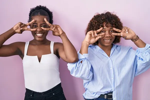 Dos Mujeres Africanas Pie Sobre Fondo Rosa Haciendo Símbolo Paz —  Fotos de Stock