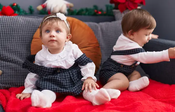 Δύο Αξιολάτρευτα Μωρά Κάθονται Στον Καναπέ Χριστουγεννιάτικη Διακόσμηση Στο Σπίτι — Φωτογραφία Αρχείου