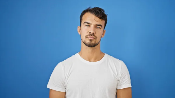 Jovem Hispânico Homem Com Expressão Séria Sobre Fundo Azul Isolado — Fotografia de Stock