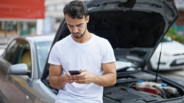 Genç İspanyol adam araba arızası için sigorta şirketine mesaj atıyor.