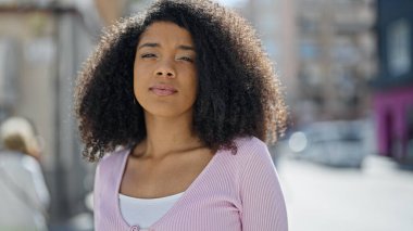 Sokakta ciddi bir ifadeyle duran Afrikalı Amerikalı kadın.