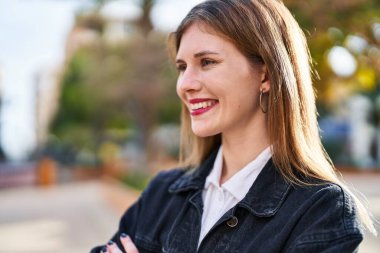 Young blonde woman smiling confident looking to the side at park