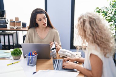 Two women business workers using laptop working at office
