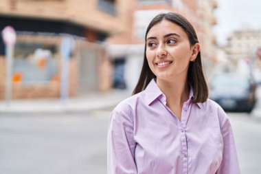 Sokakta kendine gülen genç İspanyol kadın.