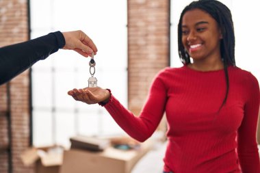African american woman smiling confident holding key at new home