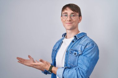 Beyaz, sarışın, gözlüklü adam gülümseyerek içeri girmeye davet ediyor. 