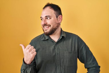 Ayrıca sarı arka planda sakallı, mutlu yüzüyle gülümseyen ve baş parmağıyla yüzünü gösteren İspanyol bir adam.. 