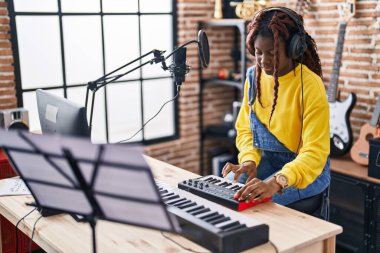Afrikalı Amerikalı kadın müzisyen müzik stüdyosunda DJ seansı yapıyor.