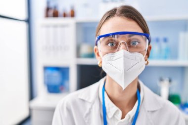Young caucasian woman scientist wearing medical mask at laboratory