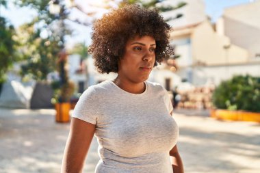 African american woman looking to the side with serious expression at park